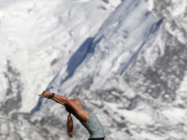 French Alps. Mont-Blanc massif. Woman doing yoya meditation on mountain.